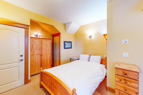 Tree Tops 12 - Suite في منتجع التزلج الأبيض الكبير: غرفة نوم بسرير ابيض وخزانة خشبية