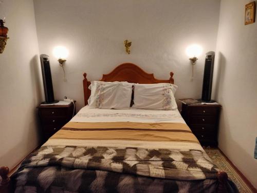 1 dormitorio con 1 cama con 2 mesitas de noche y 2 altavoces en Casa da Lomba, en Arganil