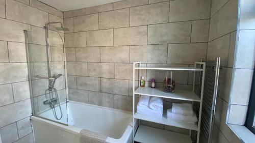 y baño con ducha, bañera y lavamanos. en Roomy 2 bed flat in London en Thornton Heath