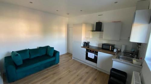 sala de estar con sofá azul en la cocina en Roomy 2 bed flat in London en Thornton Heath