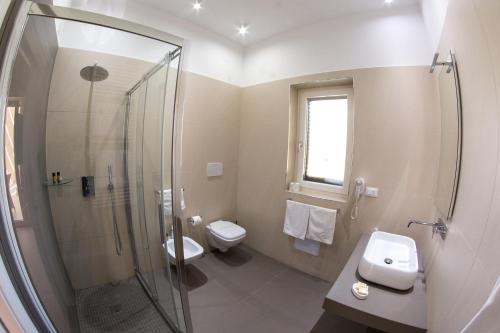 a bathroom with a shower and a toilet and a sink at Isola Verde Agriturismo in Carovigno