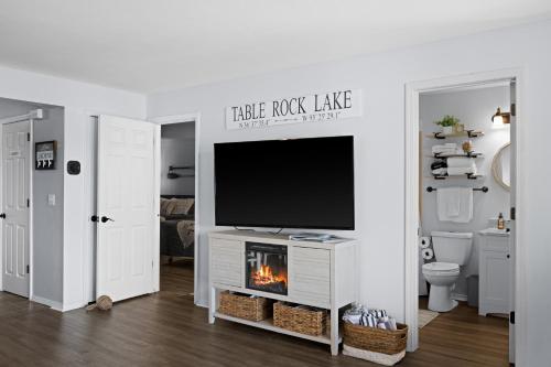 a living room with a tv and a fireplace at Lakefront, Fireplace Home Near Silver Dollar City in Kimberling City