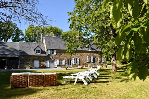 een groep witte picknicktafels voor een gebouw bij Gîte du Rochelu 4 Étoiles 5000 m2 of Garden, near to Mont Saint Michel & Granville island in Bourguenolles