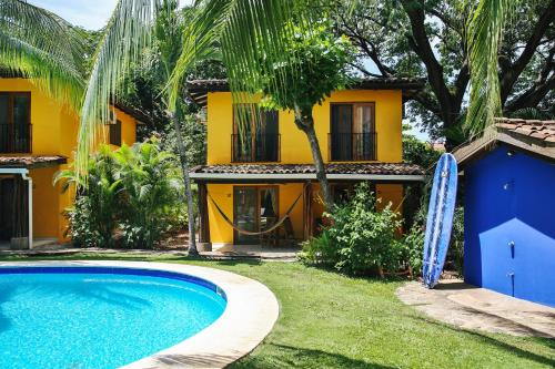 a villa with a swimming pool in front of a house at Villas Macondo in Tamarindo