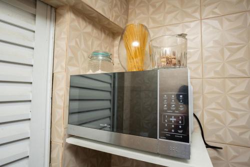 un forno a microonde seduto su uno scaffale in cucina di Otima casa com Wi-Fi em Santa Teresa ES a Santa Teresa