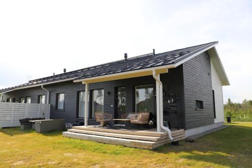 a black house with a porch and a patio at Big apartment, near Santaclaus Village in Rovaniemi