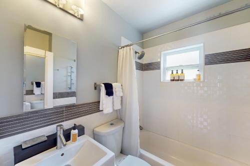 een badkamer met een wastafel, een toilet en een spiegel bij The Lakeland House in Lakeland