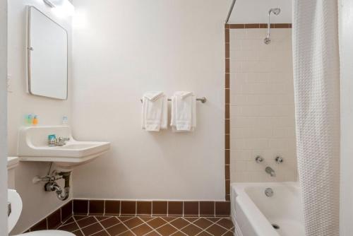 La salle de bains est pourvue d'un lavabo, de toilettes et d'une douche. dans l'établissement Hotel St. Michael, à Prescott