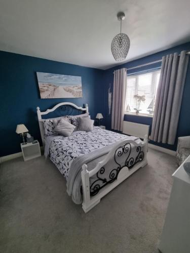 a bedroom with a bed with a blue wall at Dungarvon House B&B, Weston-super-Mare, Exclusive Bookings, Private Hot tub in Weston-super-Mare