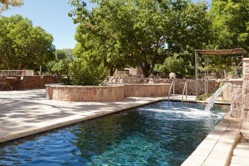 uma piscina com uma fonte num quintal em Protea Hotel by Marriott Bloemfontein Willow Lake em Bloemfontein