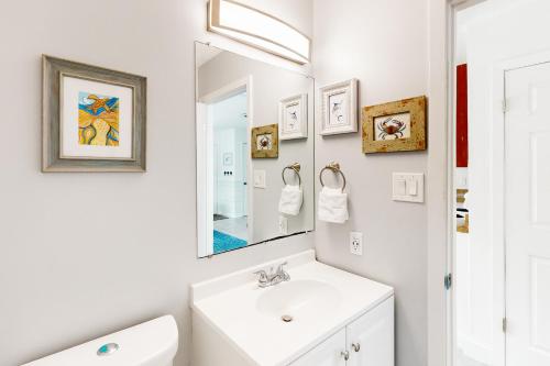 a white bathroom with a sink and a mirror at Fenwick A in Ocean City