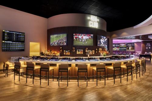 a large bar with stools in a room with a stage at Harrah's Gulf Coast, A Caesars Destination in Biloxi