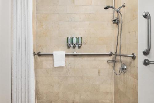 a bathroom with a shower with a shower curtain at Viana Hotel and Spa, Trademark Collection by Wyndham in Westbury