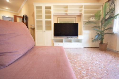 a living room with a tv and a bed at La Casa di Daniela in Lido di Ostia