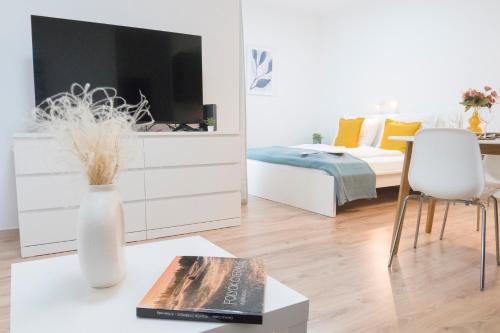 a living room with a bed and a table with a vase at K111 Klapka Apartment in Budapest