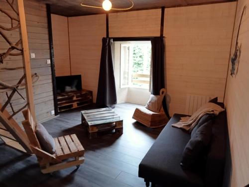 uma sala de estar com um sofá e uma janela em Gîte le lénio em Langogne