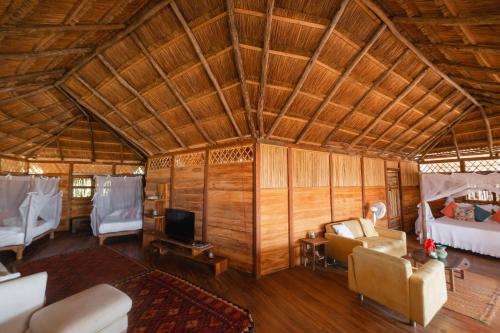 Habitación con cama, sofá y TV. en Awatawaa Ecolodge en La Punta de los Remedios