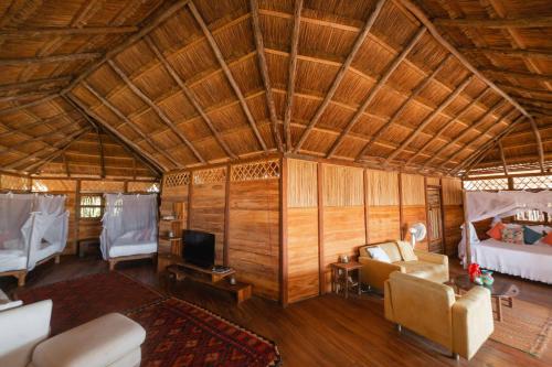 La Punta de los RemediosにあるAwatawaa Ecolodgeのベッドとソファとテレビのある部屋