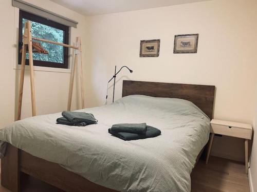 1 dormitorio con 1 cama con 2 almohadas en Prachtige chalet in het bos met sauna! en Lanaken
