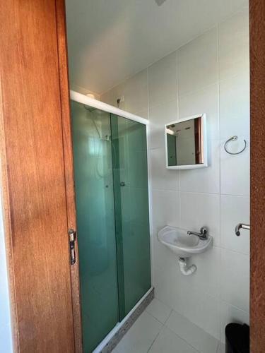a bathroom with a glass shower and a sink at Apto acolhedor na Passagem in Cabo Frio