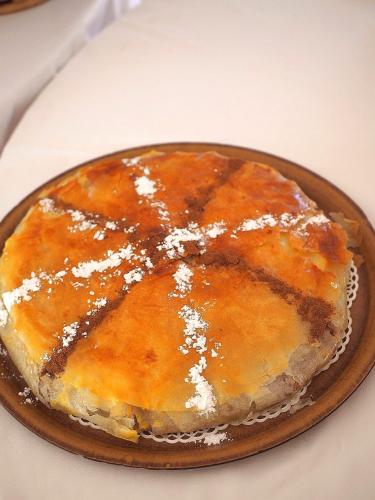 a cake on a plate with powdered sugar on it at Paradis Nomade in Azrarag