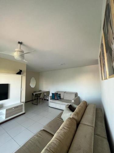 a living room with a couch and a tv at Apto acolhedor na Passagem in Cabo Frio