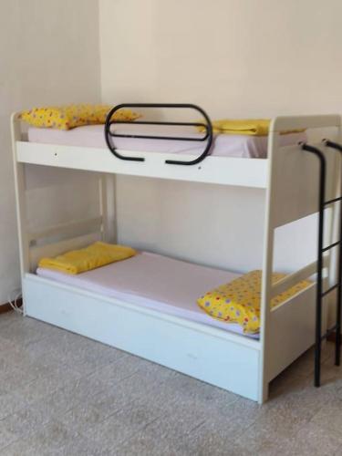 a bunk room with two bunk beds with yellow sheets at Casa nel centro storico a Loreto, 2 km dal mare in Loreto