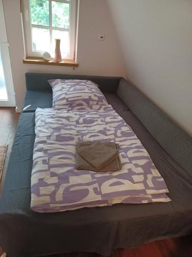 a bed in a small room with a blanket on it at Ferienhaus Elbliebe - kleine Hunde bis 25 cm willkommen in Dannenberg