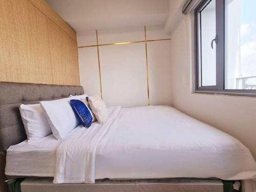 een bed in een kleine kamer met een raam bij Grass Residences T4 383 in Manilla