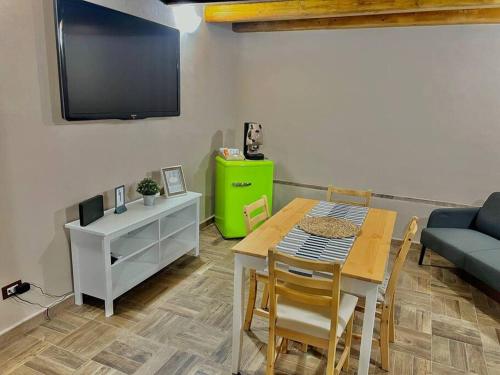uma sala de estar com uma mesa e um sofá verde em Little House 51, Palermo em Palermo