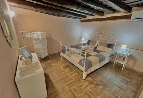um quarto com uma cama branca e piso em madeira em Little House 51, Palermo em Palermo