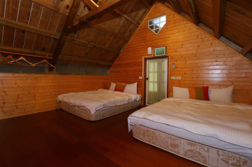 zwei Betten in einem Zimmer mit Holzwänden in der Unterkunft Dongshan River Resort Farm in Wujie
