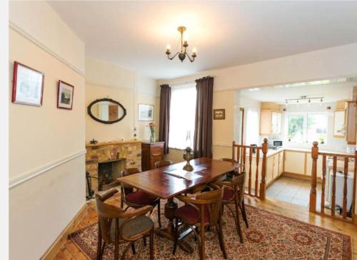 a dining room with a table and chairs and a fireplace at Fishermen Cottage - 5 star location- 90sq garden -2 living room- 2 bath room -pets friendly -comfortably sleep 5-6 people -50 percent off monthly -self check in in Deal