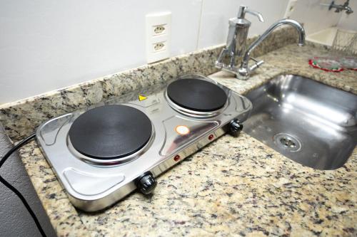 a stove top oven sitting next to a sink at Loft c localizacao perfeita e WiFi-Santa Teresa ES in Santa Teresa