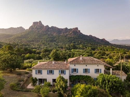 una casa blanca con una montaña en el fondo en Le Pré Lilas, en Roquebrune-sur-Argens