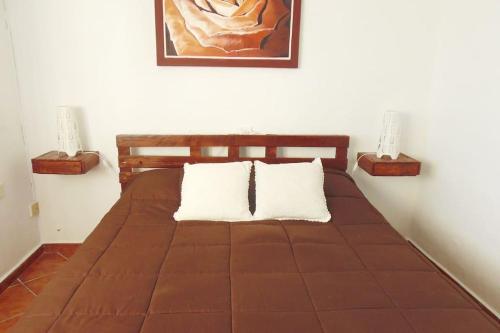 1 dormitorio con 1 cama marrón y 2 lámparas en Apartamento con vistas (La Casita de Luísa), en Mocanal