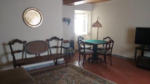 a living room with a table and chairs and a television at A Vista dos Verdes in Furnas