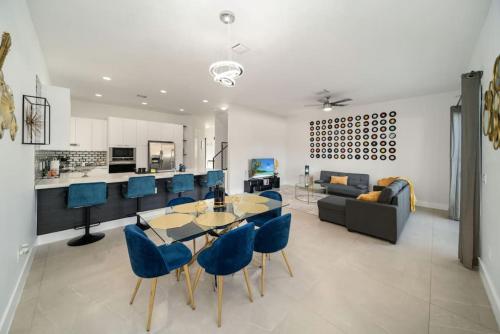 a living room with a table and blue chairs at Modern RocknHome Near Hard Rock and FLL Airport in Fort Lauderdale