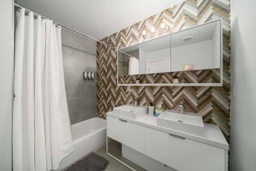a bathroom with a sink and a mirror and a tub at Modern RocknHome Near Hard Rock and FLL Airport in Fort Lauderdale