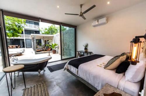 a master bedroom with a large bed and a bathtub at Beautifully Designed 3-BR Escape Close to Downtown in Tulum