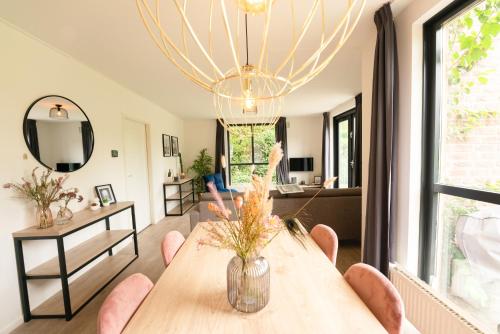 a living room with a wooden table and chairs at Goldenescape 6P Vip cottage met royale tuin en Hottub in Ewijk