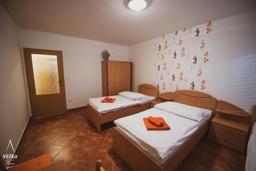 a room with two beds with orange towels on them at Pension Věžka in Šternberk
