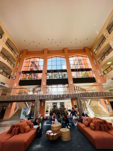 a large lobby with couches and people in a building at Flat Partic Hotel Jurere Beach Village in Florianópolis