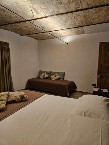 a bedroom with two beds and a wooden ceiling at DESTASU' Apartments in Castel del Monte