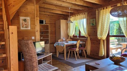 a dining room with a table in a wooden cabin at Ferienhaus Bliev-Hee Nr 2 in Klink