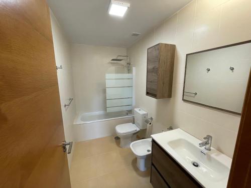 La salle de bains est pourvue de toilettes, d'un lavabo et d'un miroir. dans l'établissement Apartamento golf-resort murcia, à Murcie