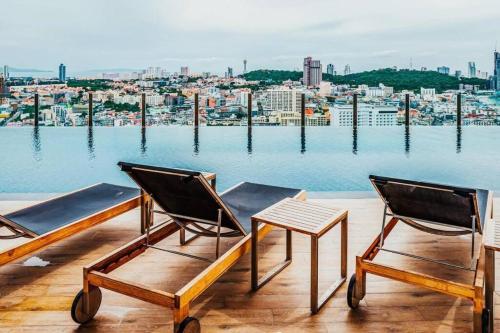 two chairs and a table on a balcony overlooking the water at Sea View 2 Bed Room Condo @ Central Pattaya in Pattaya Central