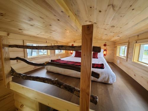 a bedroom in a log cabin with two beds in it at Tiny Digs Lakeshore - Tiny House Lodging in Muskegon