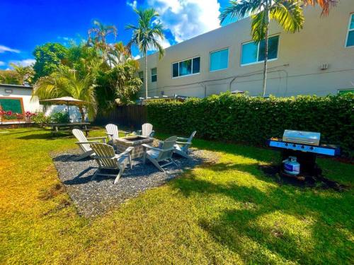 a backyard with a table and chairs and a grill at The Amazon at Holiday Park near Las Olas Beach in Fort Lauderdale