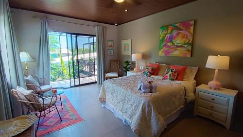a bedroom with a bed and a large window at Suite La Orquidea in Tamarindo